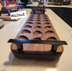 a wooden bench sitting on top of a kitchen counter next to a knife holder with holes in it