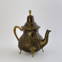 an antique teapot with a lid and handle is shown on a white background in this image