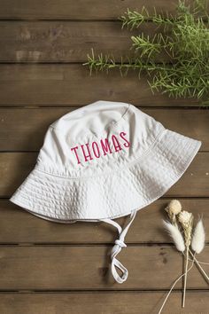 Get your little one ready for their first summer adventures! A super cute and adjustable gender neutral summer hat for baby or toddler, personalized with their first name! Bucket hats are available in your choice of white or cargo and baby name is custom embroidered using a sturdy, high-quality thread. The personalized detail of the hat makes it extra special! Perfect for a day at the beach, shore or camping and these customized bucket hats make a stand-out baby gift! Buyer customizations are: Cute Adjustable Wide Brim Sun Hat, Cute Wide Brim Adjustable Sun Hat, Fun Beach Sun Hat With Adjustable Fit, Cute Adjustable Sun Hat With Uv Protection, White Wide Brim Hat For Playtime, Fun Adjustable Beach Sun Hat, Cute Adjustable Fit Sun Hat For The Beach, Playful Adjustable Sun Hat For The Beach, Cute Adjustable Fit Sun Hat For Beach