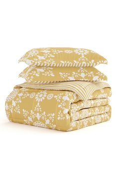 four sheets stacked on top of each other in yellow and white floral print, with one folded