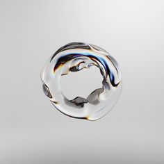 an abstract glass sculpture is shown against a white background and appears to be floating in the air