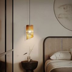 a bedroom with a bed and a lamp hanging from the ceiling over it's headboard