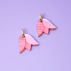 These Tulip charms add a lovely monochrome pop of color and are small and cute enough for when you want to be a little subtle. Hand-crafted from a combo of marbled, mirrored and frosted acrylic, paired with hand-stained wood. They hang from elegant 15mm gold-filled hoops and are removable so you can wear the hoops on their own—two earrings in one, perfect for travel! Hand-crafted in New York City. Gold-filled hoops are perfect for sensitive ears! Due to the hand-made nature of these pieces, your Vynil Earrings, Everyday Pink Jewelry With Flower Charm, Diy Resin Earrings, Tulip Earrings, Two Earrings, Red Charm, Hoop Charms, Frosted Acrylic, Purple Tulips