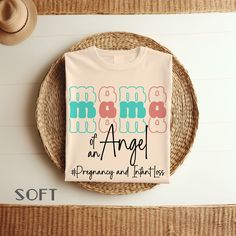 a t - shirt with the words mom of an angel on it next to a straw hat