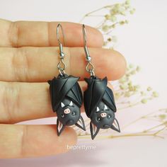 a pair of black bats hanging from earrings