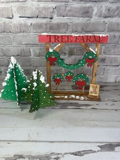 there is a small christmas tree next to a wooden sign that says tree farm on it