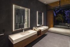 a modern bathroom with two sinks and mirrors