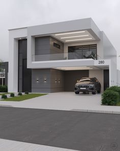 a car is parked in front of a large modern house with an open garage door