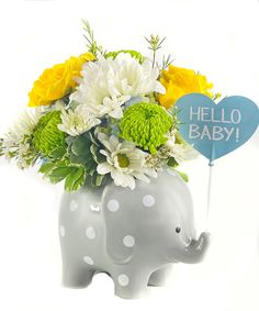 a baby elephant vase with flowers in it and a hello baby sign on the top