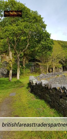 a stone wall with trees in the background and text that reads britishfraesttradespartments