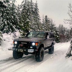 a truck driving down a snow covered road