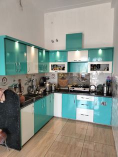 a kitchen with teal cabinets and white walls is pictured in this image from the front view