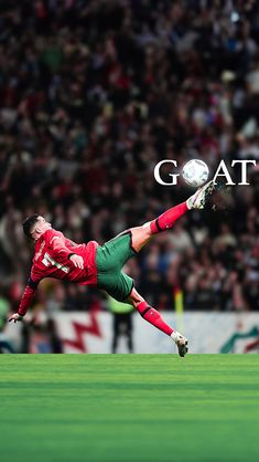 a man kicking a soccer ball on top of a field in front of a crowd