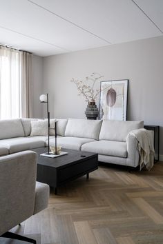 a living room filled with furniture and a large painting on the wall above the couch