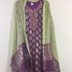 Elegant Purple And Green Jamawar Embroidered Dress-3 Pcs- Shirt Is Jamawar With Gold Embroidery Of Dabka And Stones-Long Sleeves- Scarf Is 2.5 With Purple And Green Contrast, Chiffon, Jamawar Work. Pant Is Plain Purple, Polyester, Straight And Elastic. Shirt Length 45 Inches Chest 22 Waist 21 Hips 24 Shoulders 16 Sleeves 21.5 Trouser/ Pant Length 38.5 Inches Waist 14.5 To 18.5 Inches Inseam 14 Inches Opening Of Bottom- 9 Inches Plain Purple, Gold Embroidery, Pant Length, Purple And Green, Trouser Pants, Purple Green, Embroidered Dress, Green And Purple, Green Colors