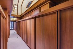 the hallway is lined with wooden doors and carpeted flooring, along with windows