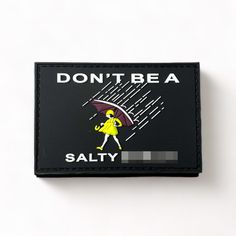 a black and white patch with a woman holding an umbrella that says, don't be a salty