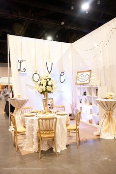 a table set up for a wedding with chairs and tables covered in white linens