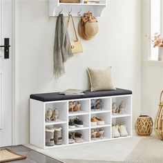 a white entryway bench with shoes on it