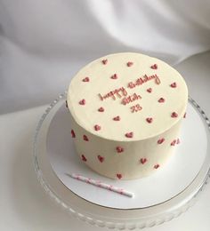 a white cake with pink hearts on it and the words happy birthday written in frosting