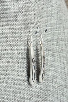 These sterling silver earrings were made by Hopi silversmith Augustine Mowa. The back is stamped sterling.Length: 1 5/8"Width: 1/4"Free shipping on all orders! We ship with USPS and always include tracking. All orders ship within a day of payment.Returns are accepted up to 30 days after you receive your order. Just send us a message. Our shop offers cash back or store credit. The item must be returned in new condition. Engraved Sterling Silver Drop Earrings, Engraved Teardrop Sterling Silver Earrings, Artisan Long Drop Sterling Silver Earrings, Classic Engraved Sterling Silver Earrings, Classic Engraved Silver Earrings, Artisan Silver Long Drop Earrings, Artisan Long Drop Silver Earrings, Silver Engraved Teardrop Earrings, Artisan Engraved Dangle Earrings