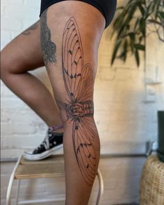 a woman's leg with a butterfly tattoo on it