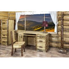 a wooden desk and chair in front of a window with mountain scenery on the wall