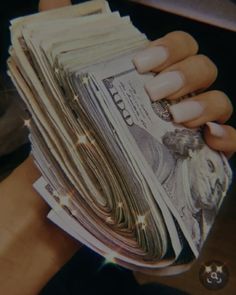 a person holding a stack of money in their hand