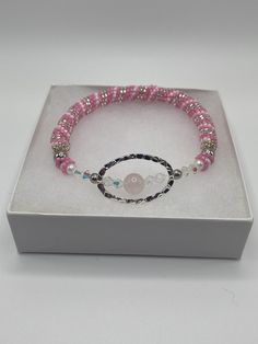 Lovely, handmade, seed bead bracelet with rose quartz and precious crystal focal. This bracelet is a slip on style and will fit a wrist of 7 inches. The bracelet is all handwoven with pink, white, clear and silver seed beads using peyote stitch and has a rose quartz focal bead with clear Preciousa crystals surrounded by a silver colored oval. This a a great gift for someone show likes beautiful, handmade, one of a kind jewelry. The bracelet will come in a white gift box ready for gift giving, Pl Cute Beaded Bracelet, Pink Beaded Bracelet, Rose Quartz Bracelet Beads, Pink Beaded Bracelets, Bracelet Cute, Seed Bead Bracelet, Rose Quartz Beads, Bracelets Handmade Beaded, Seed Bead Bracelets