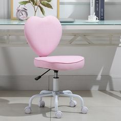 a pink heart shaped office chair sitting in front of a desk with a clock on it