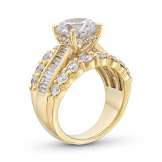 a yellow gold engagement ring with an oval cut diamond surrounded by smaller round and baguettes