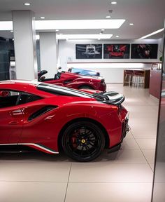 two red sports cars parked in a showroom