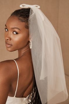 a woman wearing a white veil and dress