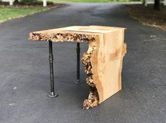 a piece of wood that has been turned into a table with metal legs on it