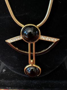 89 Jean Fouquet art deco necklace. Vintage Art Deco 89 Pendant Necklace of Jean Fouquet Design Signed. Blue Glass Stone Highly collectible ART DECO/89 necklace with two black stone attached on gold tone bar, black enamel half moon on the bottom and rhinestones on top of the  pendant. snake chain with fold over closer. exceptional necklace by Jean Fouquet, the master of Parisian jewelry in the 1920s,  Marked  ©ART DECO/89 TM with the model number B012  on the back. Boutique costume jewelry at its best. In good vintage condition . Measurements about. Chain length  27" pendant length 2.75  width 2.5  Etsy Shipping Please read -Vintage and pre-owned items may have signs of wear and use and are offered as is. Traces of age and use are therefore completely normal and do not constitute defects. P Art Deco Pendant Necklace For Formal Occasions, Formal Black Enamel Round Necklaces, Formal Round Black Enamel Necklaces, Formal Black Enamel Pendant Necklace, Luxury Black Metal Necklace, Formal Art Deco Round Necklace, Elegant Black Enamel Necklaces For Evening, Elegant Evening Black Enamel Necklaces, Elegant Evening Necklaces With Black Enamel