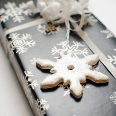 a black book with white snowflakes on the cover and ribbon tied around it