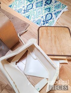 several pieces of wood are laying on the floor next to paper and other crafting supplies