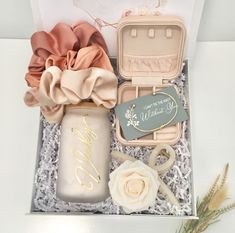 an open box with some flowers and other items in it on a white table top