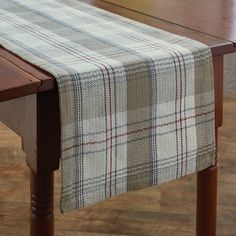 a plaid table runner on top of a wooden table