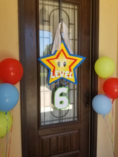 a door with balloons and a sign that says level 6 on the front glass window