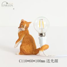 an orange cat figurine holding a light bulb