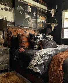 a bed room with a neatly made bed and cow heads on the wall above it