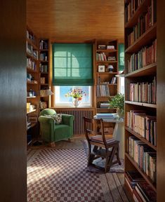 a living room filled with lots of furniture and bookshelves covered in green blinds