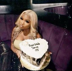 a woman sitting on a couch holding a cake