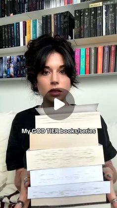 a woman holding stacks of books in front of her face