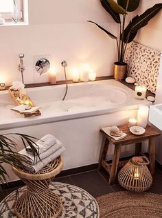 a bathtub with candles and plants in it