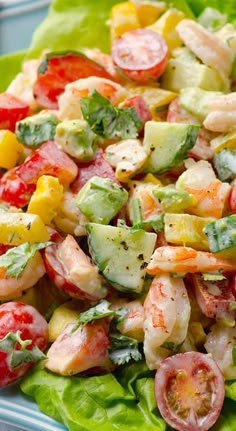 a salad with shrimp, cucumber, tomatoes and lettuce in it