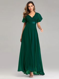 a woman in a long green dress with short sleeves and a v - neckline