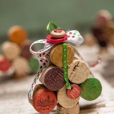 a small christmas tree made out of wine corks with a red button on top