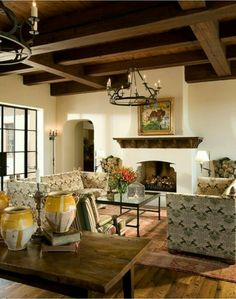 a living room filled with furniture and a fire place in the middle of a room